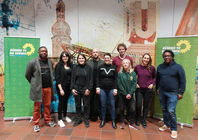 Neun Menschen stehen vor einer bemalten Wand mit Dortmunder Wahrzeichen