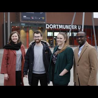 Vier Menschen stehen lachend vor dem Dortmunder U