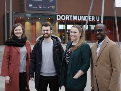Vier Menschen stehen lachend vor dem Dortmunder U