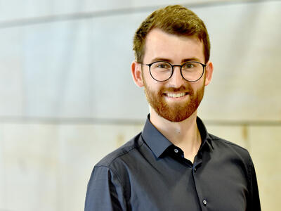 Portraitfoto: Michael Röls vor einer Wand im Landtag